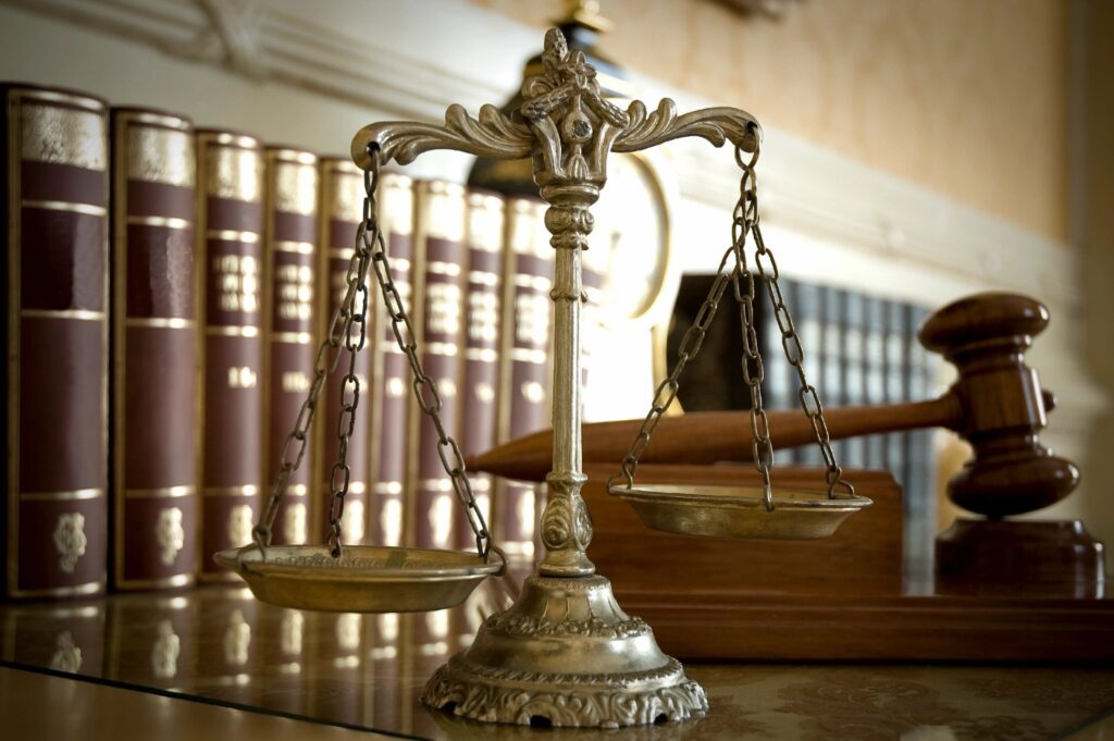 Scales of justice, gavel, and law books.